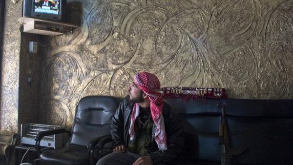 A rebel soldier watches the satellite TV news, waiting to learn his country's fate A rebel soldier watches the satellite TV news, waiting to learn his country's fate