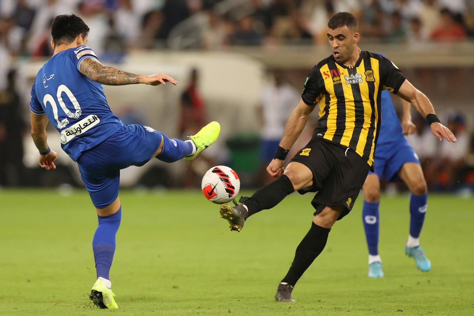 Ittihad's forward Abderrazak Hamdallah (R) is marked by Hilal's defender Jang Hyun-soo (L) during a Saudi Pro League football match between al-Ittihad and al-Hilal at the King Abdullah Sports City in Jeddah on May 23, 2022. (Photo by AFP)