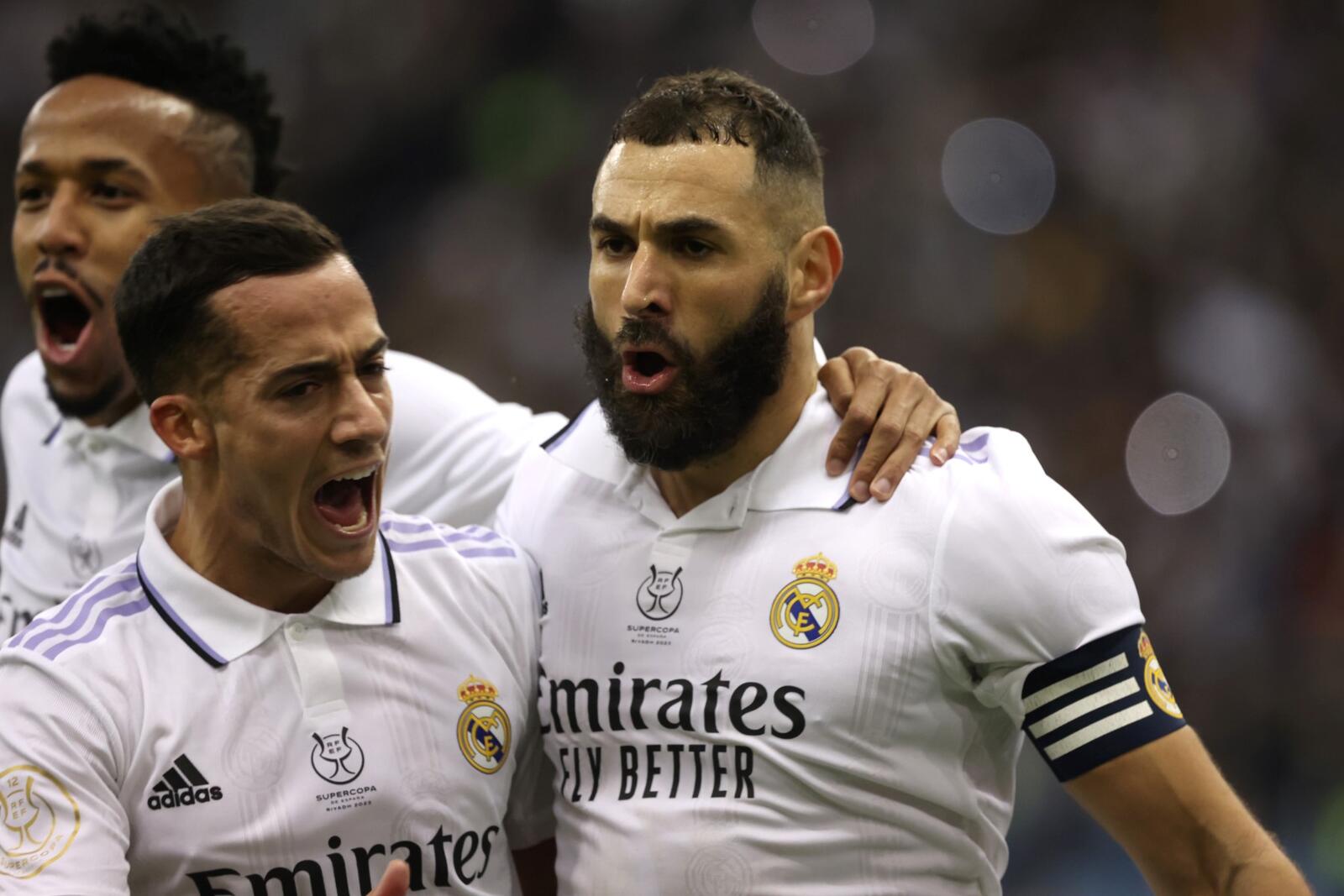 Real Madrid's French forward Karim Benzema (R) celebrates scoring the opening goal from the penalty spot, next to Real Madrid's Brazilian defender Eder Militao (L) and Real Madrid's Spanish forward Lucas Vazquez during the Spanish Super Cup semi-final football match between Real Madrid CF and Valencia CF at the King Fahd International Stadium in Riyadh, Saudi Arabia, on January 11, 2023. (Photo by Fayez Nureldine / AFP)