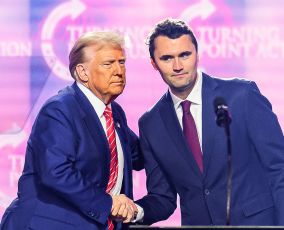 US right-wing activist Charlie Kirk (R) speaks on stage with President Donald Trump
