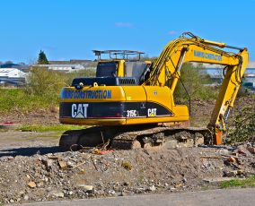 Bridgend. County Borough of Bridgend / Wales UK - 3/24/2019: New building site on the outskirts of Bridgend. A Caterpillar 315CL hydraulic excavator.