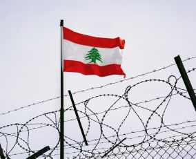 Lebanese flag behind barbed wire