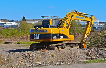 Bridgend. County Borough of Bridgend / Wales UK - 3/24/2019: New building site on the outskirts of Bridgend. A Caterpillar 315CL hydraulic excavator.