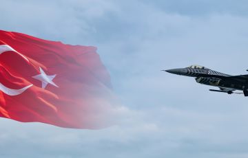 طائرة مقاتلة تركية من طراز سولوتورك F-16 تحلق أمام خلفية علم تركيا.