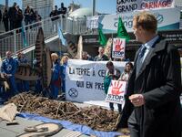 A man walks past activists of 'Extinction Rebellion' (XR) and NGO 'Planete Amazone' as they stage a protest against large hydroelectric dams in front of the Grande Arche de La Defense, in Puteaux, northwest of Paris, on May 14, 2019. AFP