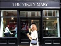 A woman walks past the Virgin Mary pub, which opened recently selling non-alcoholic drinks and is known as the 'pub with no beer', in the city centre of Dublin on May 16, 2019. PAUL FAITH / AFP