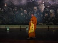 Tourists snap selfies by a bronze statue of the diver who died trying to save the 'Wild Boar' footballers from a flooded cave, while momentos from their rescue fly off the shelves -- scooped up by the 1.3 million people who have descended on a once serene mountainside in northern Thailand. Lillian SUWANRUMPHA / AFP