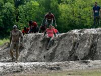 Runners cross an obstacle as they take part in the Mud Day, a 13km race with obstacles in Beynes, near Paris on June 16, 2019.  ALAIN JOCARD / AFP
