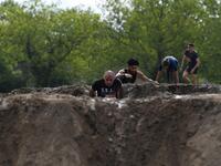 Runners cross an obstacle as they take part in the Mud Day, a 13km race with obstacles in Beynes, near Paris on June 16, 2019.  ALAIN JOCARD / AFP