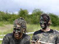 Runners wearing camouflage face paint react as they takes part in the Mud Day, a 13km race with obstacles in Beynes, near Paris on June 16, 2019.  ALAIN JOCARD / AFP