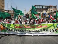 Women march with flags of the Muslim Brotherhood behind a large banner  reading in Arabic "down with the deal of the century and the normalisation  workshop of Bahrain", during a post-Friday prayers demonstration in the  Jordanian capital Amman on June 21, 2019, against US President Donald Trump's "Deal of the Century".  Khalil MAZRAAWI / AFP