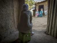 A neighbour watches as Moroccan potter Houda Oumal (C) sitting next to her mother Fatima Harama (R) paints with natural pigments on one of her pieces of pottery, near the village of Ourtzagh in the region of Taounate on june 11, 2019. FADEL SENNA / AFP