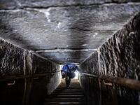 A man walks through a passage in the well-known bent pyramid of King Snefru, which had been closed to visitors since 1965, in Dahshur, some 30 kilometres (20 miles) south of Cairo, on July 13, 2019, after it was reopened by the Egyptian Antiquities Minister. Mohamed el-Shahed / AFP