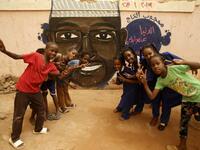 Pupils gesture in front of a mural painting of a protester killed during anti-government protests in the Sudanese capital Khartoum on July 22, 2019.  ASHRAF SHAZLY / AFP
