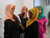 A saleswoman at the Mkeni Designs shop, dresses a mannequin with new fashion creations on November 4, 2018, in Mogadishu. Abdi HAJJI HUSSEIN / AFP