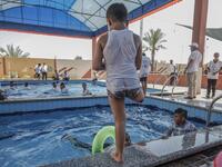 A Palestinian amputee child prepares to jump into the pool during a summer camp origanized by the Palestinian Children's Relief Fund (PCRF) in the town of Khan Yunis in the southern Gaza strip on August 3, 2019. SAID KHATIB / AFP