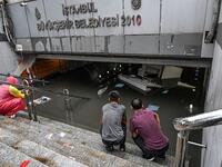 Shop owners look at their belongings in a flooded undergate shop center on August 17, 2019 in Eminonu district in Istanbul, after a heavy rainfall. Turkey's mega city Istanbul was lashed by a heavy rainstorm on August 17, killing a homeless man and leaving parts of the historic Grand Bazaar flooded.  Ozan KOSE / AFP