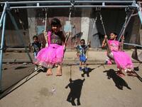 Iraqi children play on a street in Baghdad on the first day of Eid al-Adha. AFP/File Photo