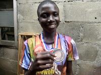 Fourteen-year-old mechanic Jamiu Ninilowo holds a medal he won following a chess tournament at Ogolonto in Ikorodu district of Lagos, on August 17, 2019. In front of chess boards in Lagos, children are busy, concentrating.  PIUS UTOMI EKPEI / AFP