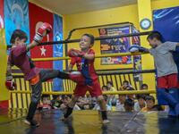 In this photograph taken on August 29, 2019, children from Muslim Uighur minority take part in a training boxing match as a trainer and children watch in Istanbul. BULENT KILIC / AFP