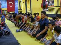 In this photograph taken on August 29, 2019, trainers and children from Muslim Uighur minority pray as they attend a Muay Thai training session in a boxing academy in Istanbul. BULENT KILIC / AFP