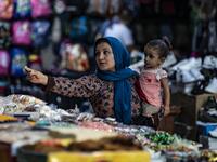 A woman pays a merchant at a market in the Kurdish-majority city of Qamishli in northeast Syria.  Delil SOULEIMAN / AFP