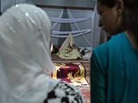 In this photo taken on September 15, 2019, guests look at a bride (C) with her face and body covered with a shawl sits in her new husband's home following their marriage in Kashmir's Baramulla district, north of Srinagar. TAUSEEF MUSTAFA / AFP