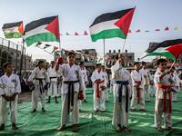 Young Palestinian karatekas wave Palestinian flags during a Karate promotion ceremony at a sporting centre in the Rafah camp for Palestinian refugees in the southern Gaza Strip on September 20, 2019. SAID KHATIB / AFP