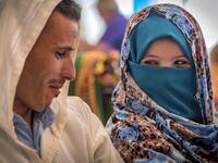 A young Amazigh (Berber) couple smile at each other as they wait for their wedding ceremony during the annual "Engagement Moussem" festival near the village of Imilchil in central Morocco's high Atlas Mountains on September 21, 2019. Each year in the High Atlas Mountains hamlet of Ait Amer, tribes celebrate with dances and music, the collective wedding of young Amazigh couples during the traditional festival of "Engagement Moussem". FADEL SENNA / AFP