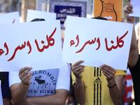 Arabic slogans on placards call for an end to violence against women and introducing a law for family protection against domestic violence."  (Twitter)