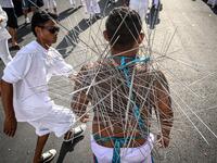 A devotee of a Chinese shrine with multiple needles pierced through his cheeks takes part in a procession during the annual Vegetarian Festival in Phuket on October 4, 2019.MLADEN ANTONOV / AFP