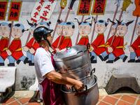 A volunteer carries empty pots at a Chinese shrine during the annual Vegetarian Festival in Phuket on October 5, 2019. Mladen ANTONOV / AFP