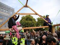 Climate change activists from the group Extinction Rebellion sit atop a temporary wooden structure as they demonstrate on Lambeth Bridge in central London, on October 7, 2019. Extinction Rebellion has scheduled non-violent protests chiefly in Europe, North America and Australia over the next fortnight. ISABEL INFANTES / AFP