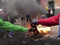 Demonstrators pass on a Molotov cocktail during clashes with riot police in Quito on October 9, 2019 on the second day of violent protests over a fuel price hike ordered by the government to secure an IMF loan. Martin BERNETTI / AFP