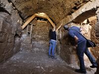 Timnah Goloubin (L), an archaeologist with the Israel Antiquities Authority, shows on October 23, 2019 the ancient church crypt in the Israeli city of Bet Shemesh. A magnificent 1500-year-old church, decorated with spectacular mosaic floors and Greek inscriptions, was discovered during a three-year excavation near a residential area. MENAHEM KAHANA / afp