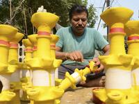 A craftsman paints earthen lamps ahead of the Hindu festival of Diwali in Amritsar on October 25, 2019.  NARINDER NANU / AFP