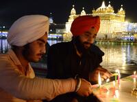 Indian Sikh devotees light candles as they pay their respects on the eve of "Bandi Chhor Divas" or "Diwali" at the illuminated Golden Temple, in Amritsar on October 26, 2019. Sikhs celebrate 'Bandi Chhor Divas', also on the same day as the Hindu festival of Diwali, to mark the historic return of the sixth Guru, Guru Hargobind NARINDER NANU / AFP