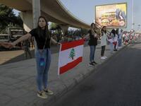 Lebanese protesters hold hands to form a human chain along the coast from north to south as a symbol of unity, during ongoing anti-government demonstrations in the southern Lebanese port city of Sidon on October 27, 2019. Mahmoud ZAYYAT / AFP
