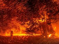A photographer takes photos amid a shower of embers as wind and flames rip through the area during a wildfire near Geyserville, Calif. (Josh Edelson/AFP via Getty Images)
