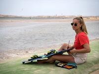 A picture taken on October 10, 2019, shows a kitesurfer fixing her board at Dakhla beach in Morocco-administered Western Sahara. In the heart of disputed Western Sahara, a former garrison town has become an unlikely tourist magnet after kitesurfers discovered the windswept desert coast on the Atlantic is perfect for their sport. FADEL SENNA / AFP