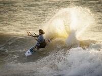 A picture taken on October 10, 2019, shows a kitesurfer riding waves at Dakhla beach in Morocco-administered Western Sahara. In the heart of disputed Western Sahara, a former garrison town has become an unlikely tourist magnet after kitesurfers discovered the windswept desert coast on the Atlantic is perfect for their sport. FADEL SENNA / AFP