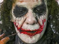 Venezuelan migrant Johnny Tales (R), who makes a living imitating the comicbook and film character "The Joker", applies make up as he prepares to work in downtown Medellin, on October 28, 2019. JOAQUIN SARMIENTO / AFP