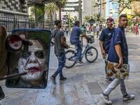 Venezuelan migrant Johnny Tales, who makes a living imitating the comicbook and film character "The Joker", applies make up as he prepares to perform in downtown Medellin, on October 28, 2019. JOAQUIN SARMIENTO / AFP