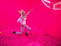 A woman jumps into a ball bath at the "Supercandy Pop-Up Museum Vol. 2" in Cologne, western Germany on November 1, 2019. It is an interactive museum and offers a photo backdrop for social media at 25 stations. INA FASSBENDER / AFP