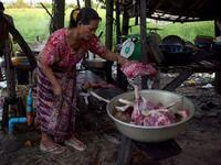 This photo taken on October 25, 2019 shows a woman preparing dog meat for customers at a slaughterhouse in Siem Reap province. Cambodian dog meat traders drown, strangle and stab thousands of canines a day in a shadowy but sprawling business that traumatises workers and exposes them to deadly health risks like rabies. TANG CHHIN Sothy / AFP