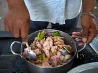 This photo taken on October 25, 2019 shows a man preparing to cook dog meat at a slaughterhouse in Siem Reap province. Cambodian dog meat traders drown, strangle and stab thousands of canines a day in a shadowy but sprawling business that traumatises workers and exposes them to deadly health risks like rabies. TANG CHHIN Sothy / AFP