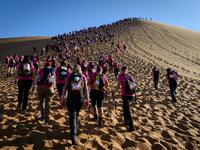 Women climb up a sand dune as they take part in the desert trek "Rose Trip Maroc", on November 4, 2019 in the erg Chebbi near Merzouga. The Rose Trip Maroc is a female-oriented trek where teams of three must travel through the southern Moroccan Sahara desert with a compass, a map and a topographical reporter. JEAN-PHILIPPE KSIAZEK / AFP