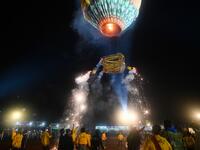 This picture taken on November 4, 2019 shows participants releasing a hot-air balloon attached with fireworks during the Tazaungdaing Lighting Festival at Taunggyi in Myanmar's northeastern Shan State. Brightly coloured balloons with hundreds of homemade fireworks woven into their frames are sent soaring into the night sky, showering down cascades of sparks onto adoring crowds in the annual Taunggyi fire balloon festival. Ye Aung THU / AFP