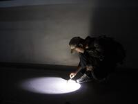 This photo taken on October 23, 2019 shows pet detective Sun Jinrong checking for feline droppings as he searches for a missing cat in a residential compound in Beijing. Private sleuth Sun Jinrong brings heat detectors, tiny surveillance cameras, and a blowdart loaded with a tranquiliser to his search for one desperate client's missing loved one: A cat named Duoduo.  NOEL CELIS / AFP