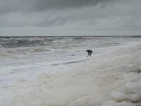 Residents play over foamy discharge, caused by pollutants, as it mixes with the surf at Marina beach in Chennai on December 1, 2019. Arun SANKAR / AFP